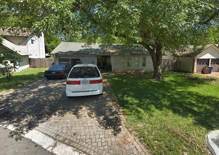 a white car parked in front of a house