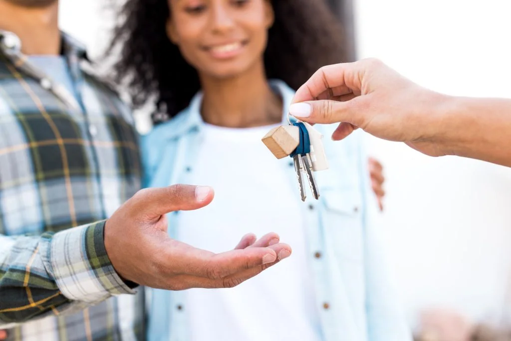 Cropped view of a landlord handing the keys to a couple