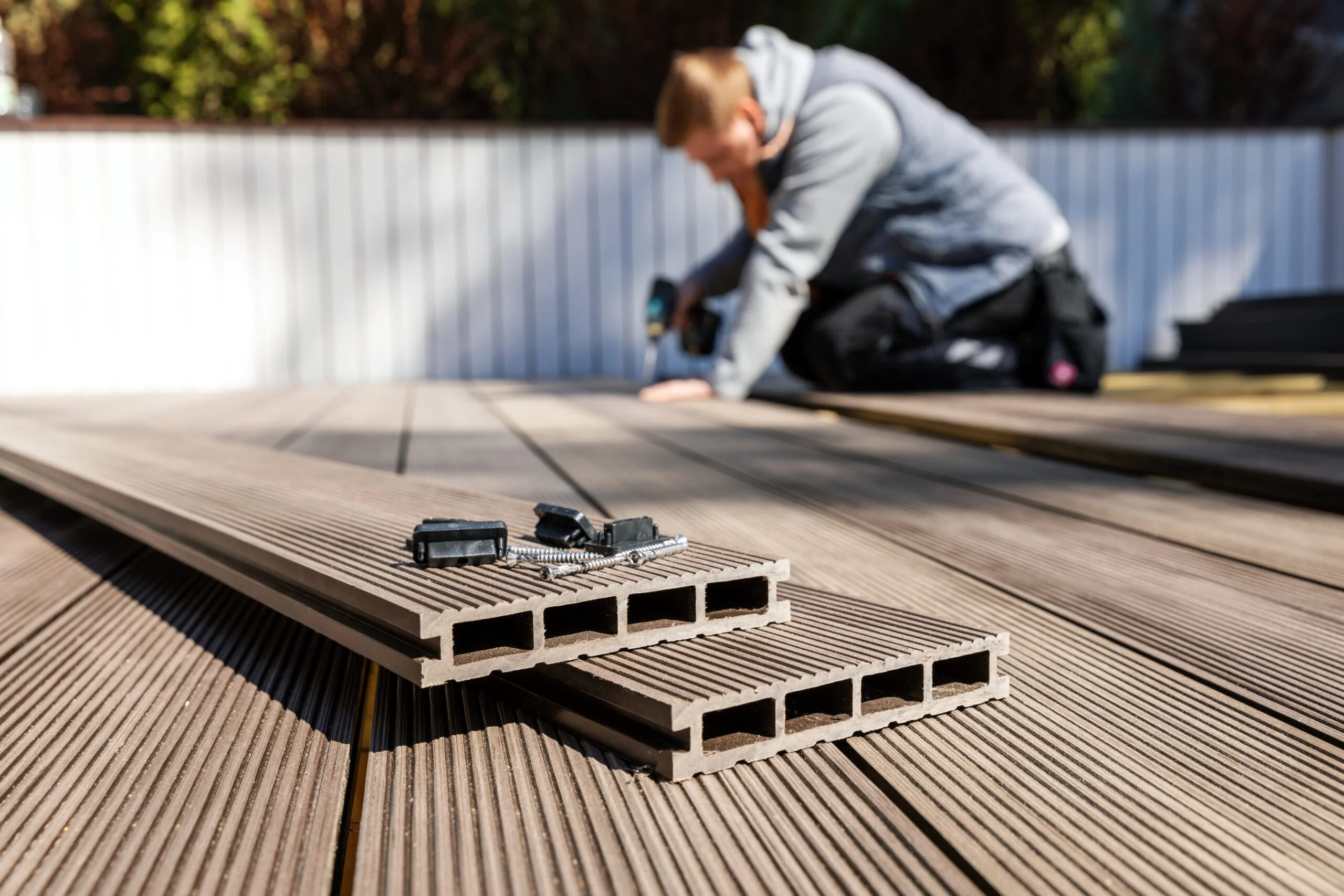a man is working on a deck with a drill